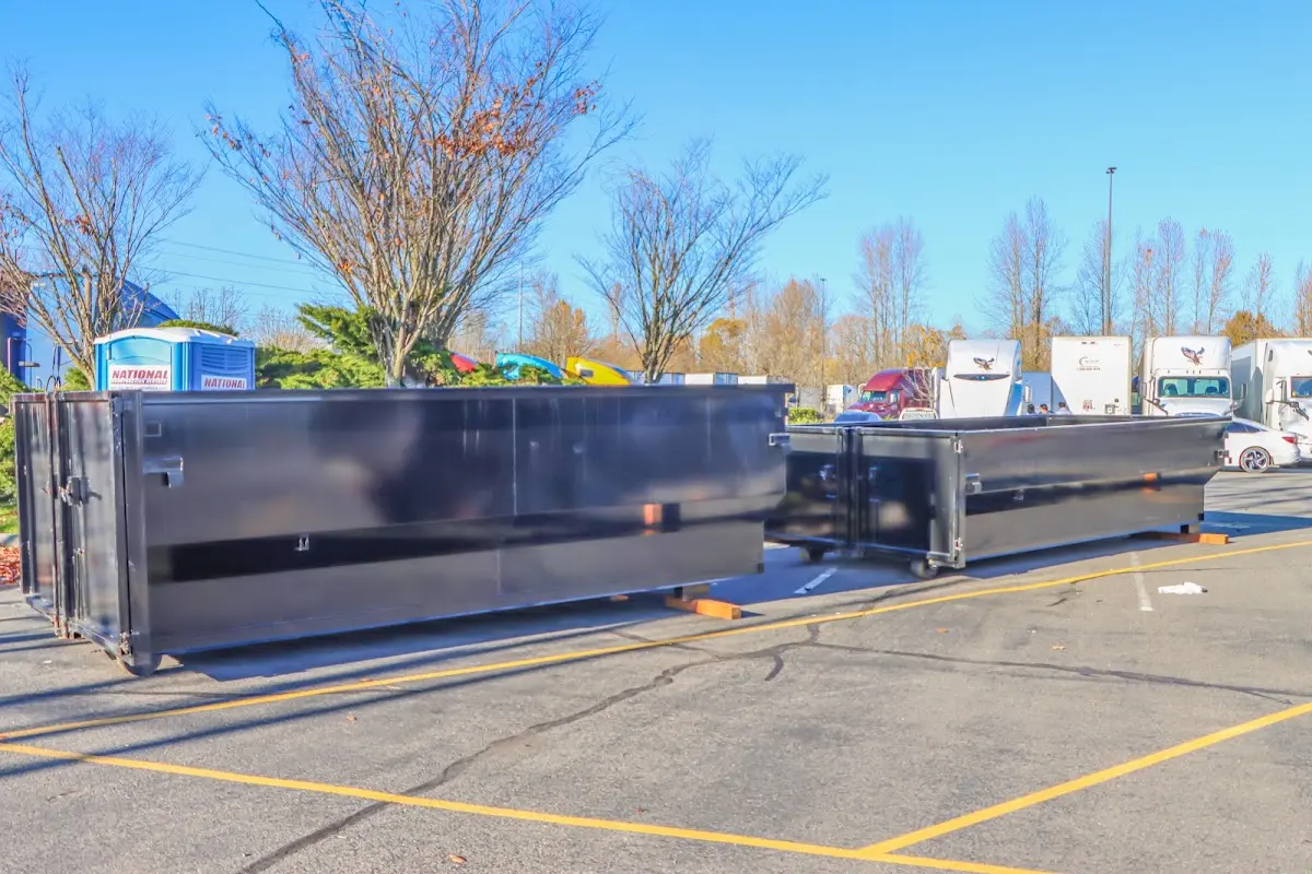 Professional dumpster rental service with roll-off container on residential driveway in Suffolk